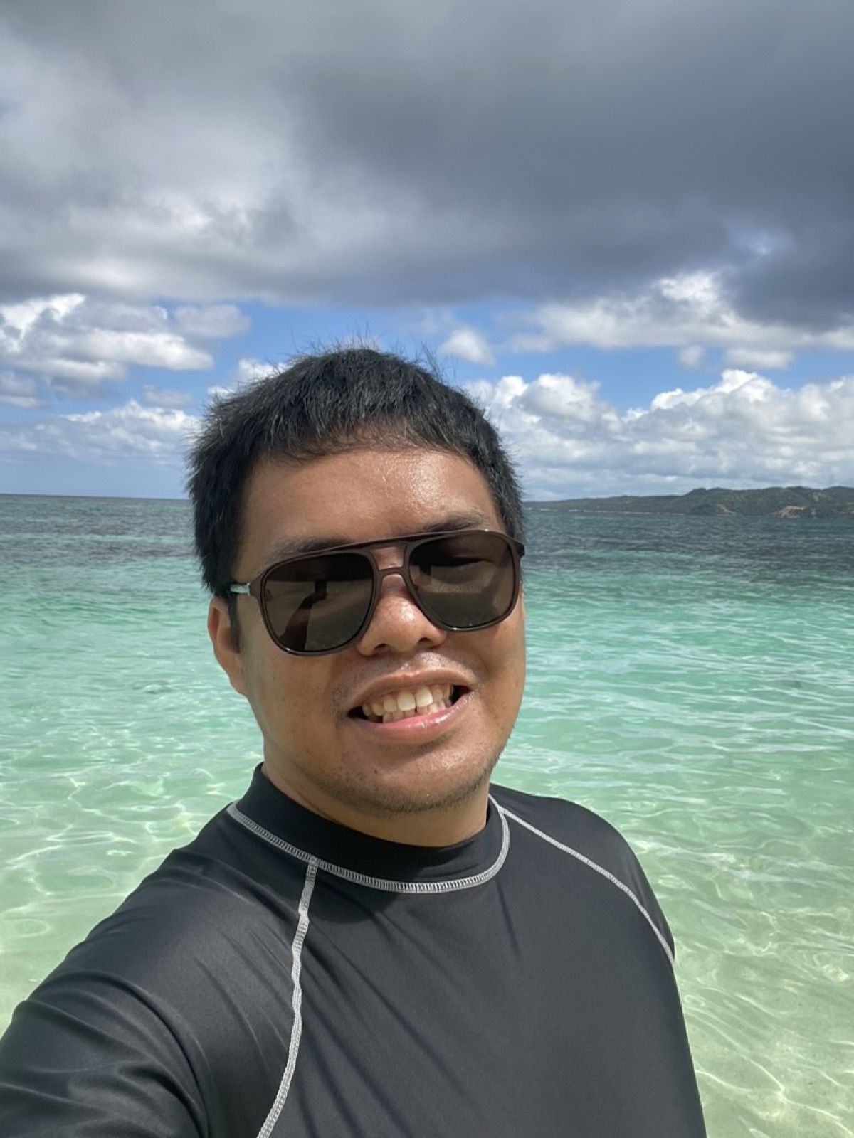Selfie in sunglasses over clear turquoise water