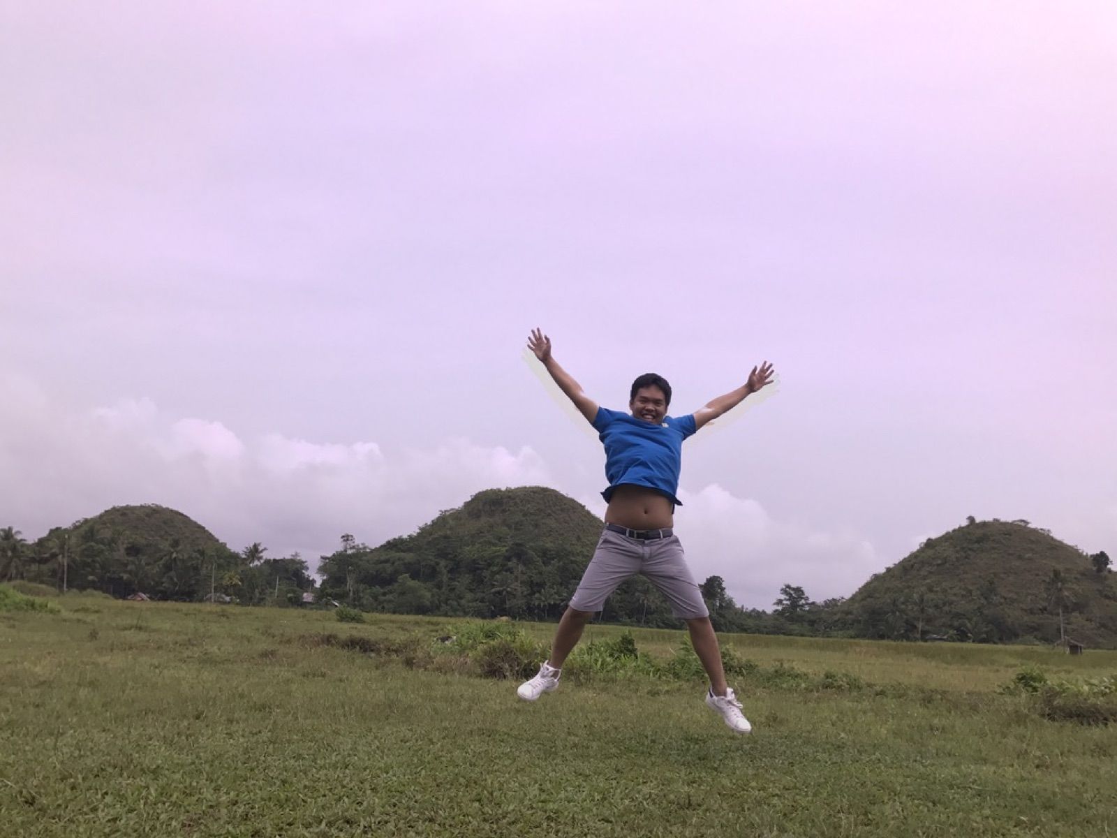 Allanaire jumping in front of rounded green hills