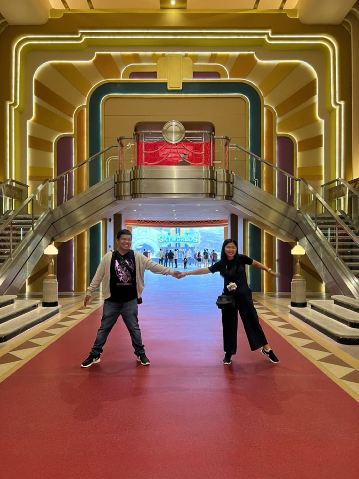 Allanaire and Honhie posing in a grand red-carpeted hall